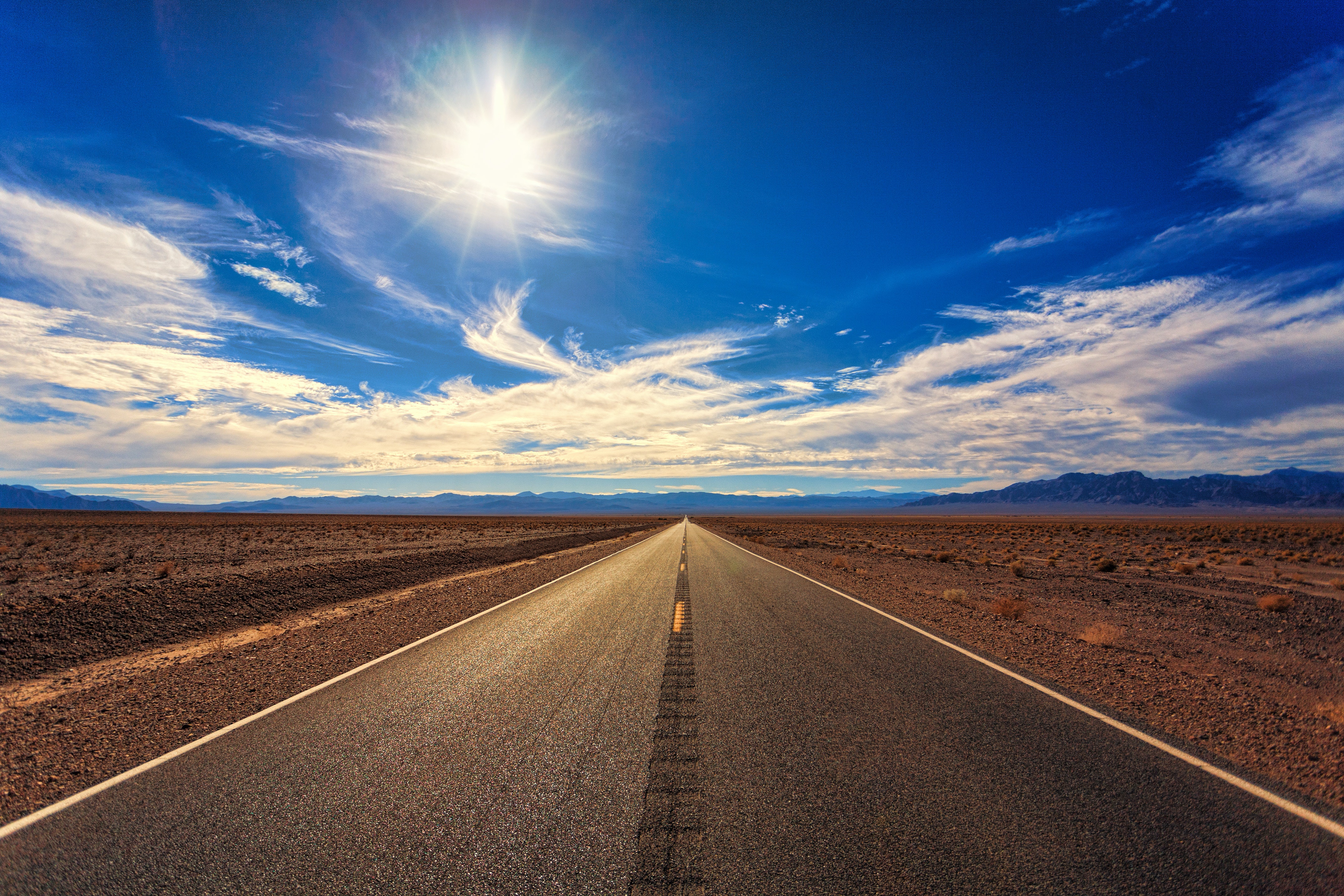 A picture of an empty road ahead, with blue sky. 